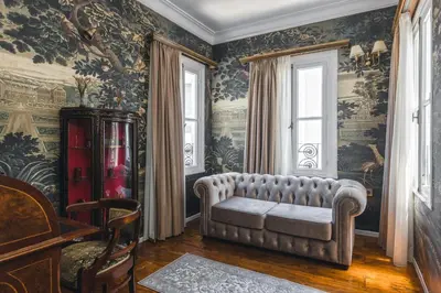 a living room with a couch in a room with wallpaper at Victoria Mansion A Luxurious Neoclassical Experience in Rhodes Town