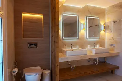 a bathroom with two sinks and two mirrors at Hillside Horizon Villa in Rhodes Town