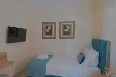 a bedroom with a blue bed with two pictures on the wall at Hillside Horizon Villa in Rhodes Town