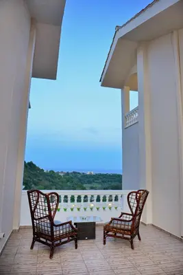 two chairs sitting on a balcony with a view at Hillside Horizon Villa in Rhodes Town