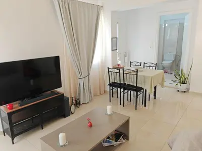 a living room with a television and a table with chairs at Leo's & Xerxes' place in the Heart of Rhodes in Rhodes Town