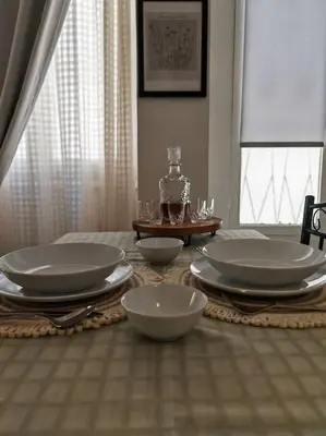 a dining room table with plates and bowls on it at Leo's & Xerxes' place in the Heart of Rhodes in Rhodes Town