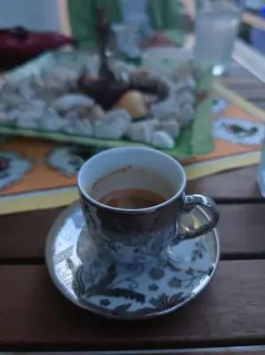 a cup of coffee on a plate on a table at Leo's & Xerxes' place in the Heart of Rhodes in Rhodes Town