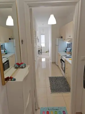 a kitchen with white cabinets and a white floor at Leo's & Xerxes' place in the Heart of Rhodes in Rhodes Town
