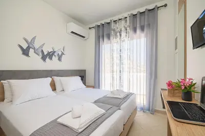 a bedroom with a bed and a desk with a laptop at Villa Mariani II - in Lothiarika, newly renovated June 2024, private pool, Lindos 10 min, beach 120m in Lardos