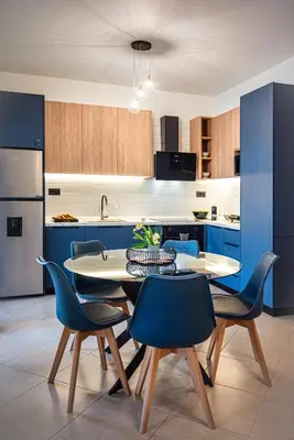 a kitchen with a table and some blue chairs at Villa Mariani II - in Lothiarika, newly renovated June 2024, private pool, Lindos 10 min, beach 120m in Lardos