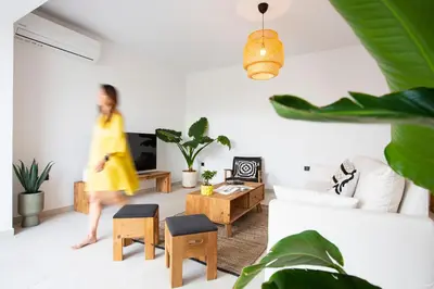 a woman walking through a living room with plants at Villa Laura in Afantou