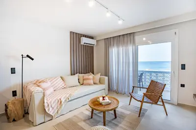 a bedroom with a bed and a table and a chair at Sunny Sands Seaview Apartment in Archangelos