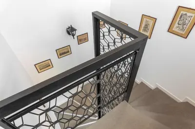 a staircase with wrought iron railings and pictures on the wall at Villa Costa Haraki in Haraki