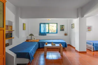 a bedroom with two beds and a table at Villa Costa Haraki in Haraki