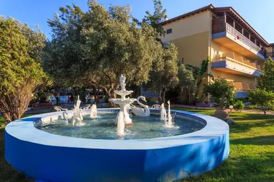 a fountain in a park in front of a building at Golden Odyssey in Kolimbia