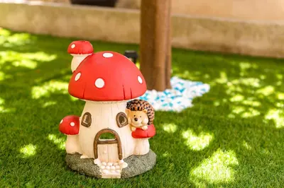 a small toy house with red mushrooms on the grass at Lilliput Garden in Rhodes Town
