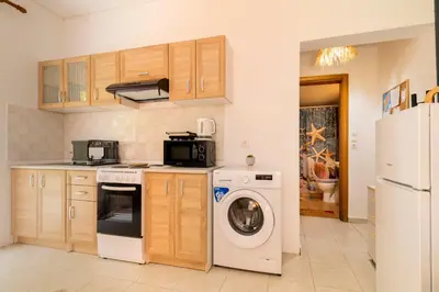 a kitchen with a washing machine and a washer at Lilliput Garden in Rhodes Town