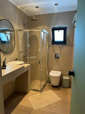 a bathroom with a shower and a sink and a toilet at City Compass Luxury Suites Faliraki in Faliraki
