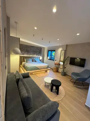 a living room with a couch and a bed at City Compass Luxury Suites Faliraki in Faliraki