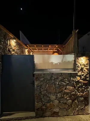 a gate in a stone wall at night at City Compass Luxury Suites Faliraki in Faliraki