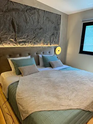 a bedroom with a bed with a large headboard at City Compass Luxury Suites Faliraki in Faliraki