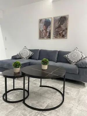 a living room with a blue couch and a table at BeeHouse in Kalithies