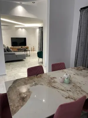 a living room with a marble table and chairs at BeeHouse in Kalithies