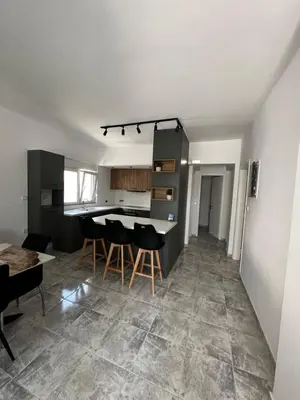 a kitchen and living room with a table and chairs at BeeHouse in Kalithies
