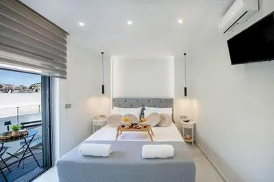 a bedroom with a large bed and a balcony at Rhodes Center Luxury Suite in Rhodes Town