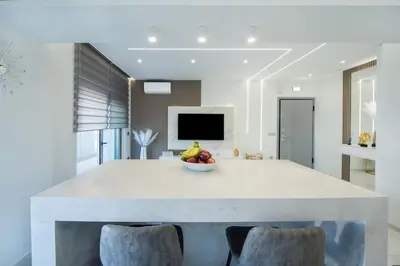 a white kitchen with a bowl of fruit on a table at Rhodes Center Luxury Suite in Rhodes Town