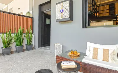 a patio with a couch and a table and plants at Chrysma Urban Living in Rhodes Town
