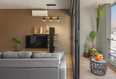 a living room with a couch and a tv at Chrysma Urban Living in Rhodes Town