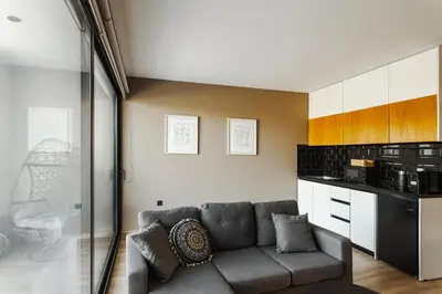 a living room with a couch and a kitchen at Chrysma Urban Living in Rhodes Town