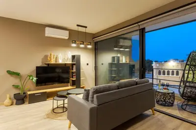 a living room with a couch and a tv at Chrysma Urban Living in Rhodes Town