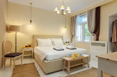 a bedroom with a bed and a table and a chair at Themis' Urban Residence in Rhodes Town