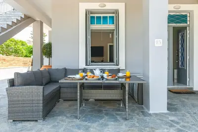 a patio with a couch and a table with food on it at Themis' Urban Residence in Rhodes Town
