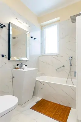 a white bathroom with a tub and a sink at Themis' Urban Residence in Rhodes Town