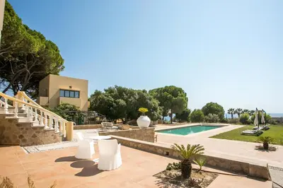 a patio with white chairs and a swimming pool at Villa Luna Piena in Pefki Rhodes