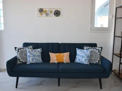 a blue couch with pillows in a living room at Gemini Apartment in Afantou
