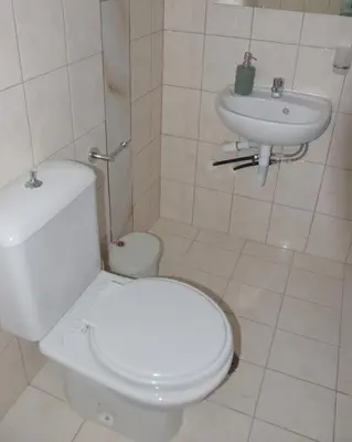 a bathroom with a white toilet and a sink at Gemini Apartment in Afantou