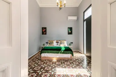 a bedroom with a bed with a green comforter at Quattro Zie in Rhodes Town