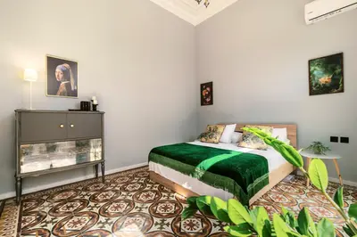 a bedroom with a bed with a green comforter at Quattro Zie in Rhodes Town