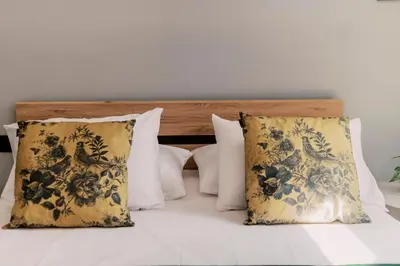 a bed with white pillows and a wooden headboard at Quattro Zie in Rhodes Town