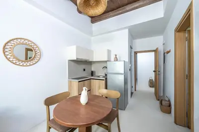 a kitchen with a table and chairs and a refrigerator at Elia Suites - Old Town in Rhodes Town
