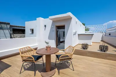 a patio with a table and chairs on a roof at Elia Suites - Old Town in Rhodes Town