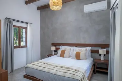 a bedroom with a large bed with white sheets at Elia Suites - Old Town in Rhodes Town