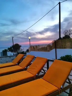a row of orange lounge chairs sitting on a patio at Alexandra's Sea Front Villa in Pefki Rhodes