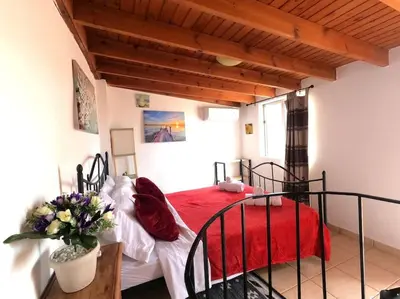 a bedroom with a bed with a red blanket at Tiny Clock House in Rhodes Town