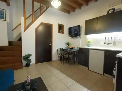a kitchen with a counter and a table with chairs at Tiny Clock House in Rhodes Town