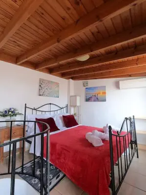 a bedroom with a large bed with a red blanket at Tiny Clock House in Rhodes Town
