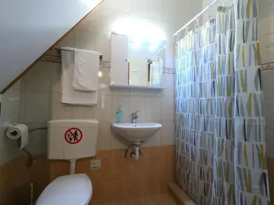 a small bathroom with a toilet and a sink at Tiny Clock House in Rhodes Town