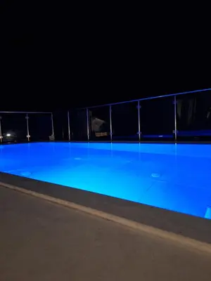 a swimming pool at night with blue illumination at Villa Pava-sea view brand new villa in Archangelos