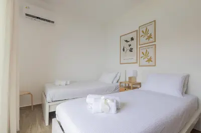 two beds in a room with white walls at Villa Pava-sea view brand new villa in Archangelos