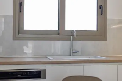 a kitchen with a sink and two windows at Villa Pava-sea view brand new villa in Archangelos